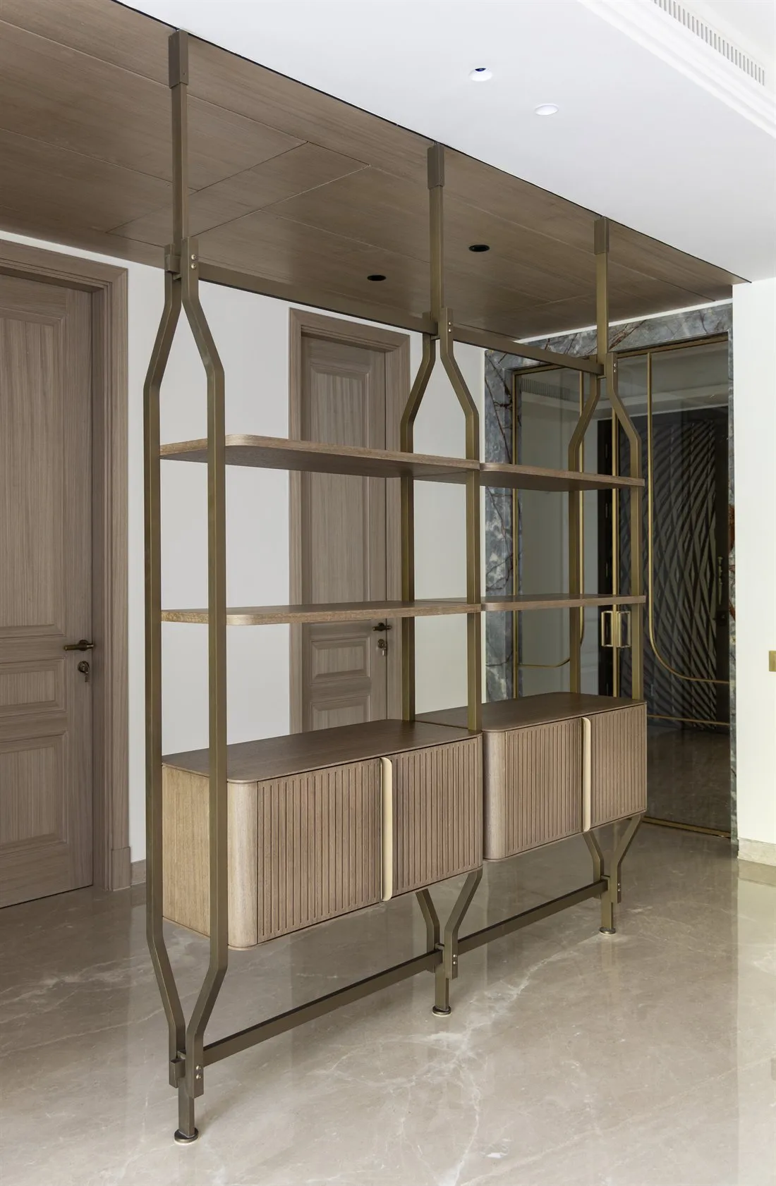 Brass-framed console and shelving unit in the entrance lobby