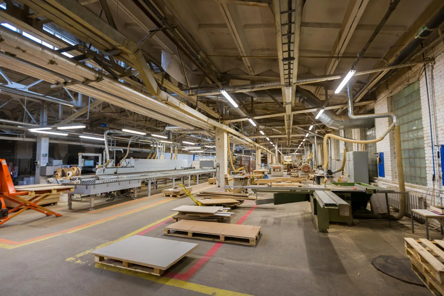 turii factory floor — panel line, edge bander and stacked boards