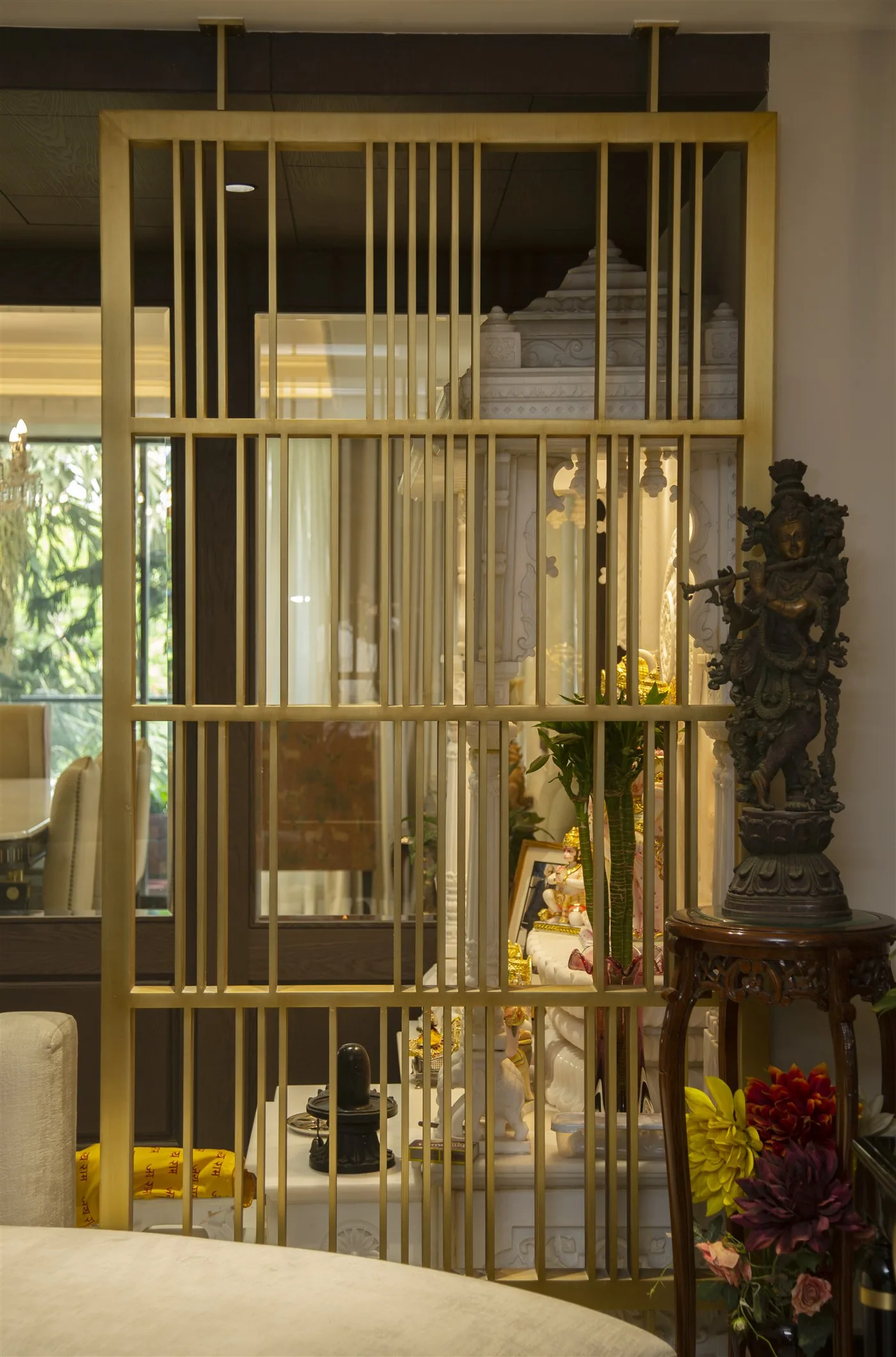 Brass screen partition with mandir beyond