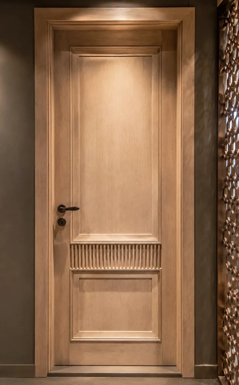 Panelled door with a fluted mid-band, beside a carved jali screen