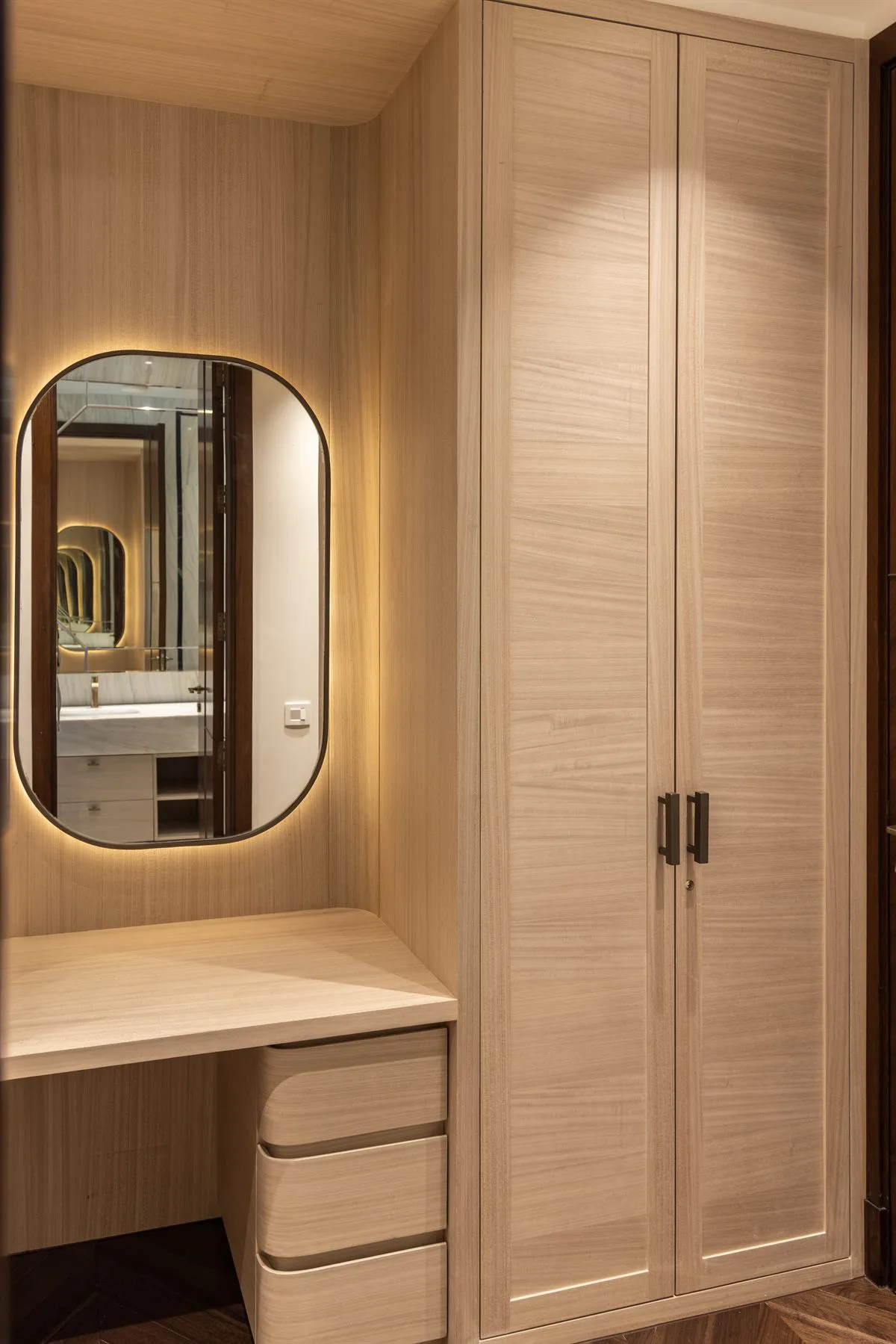 Dressing area with a backlit mirror and full-height wardrobe