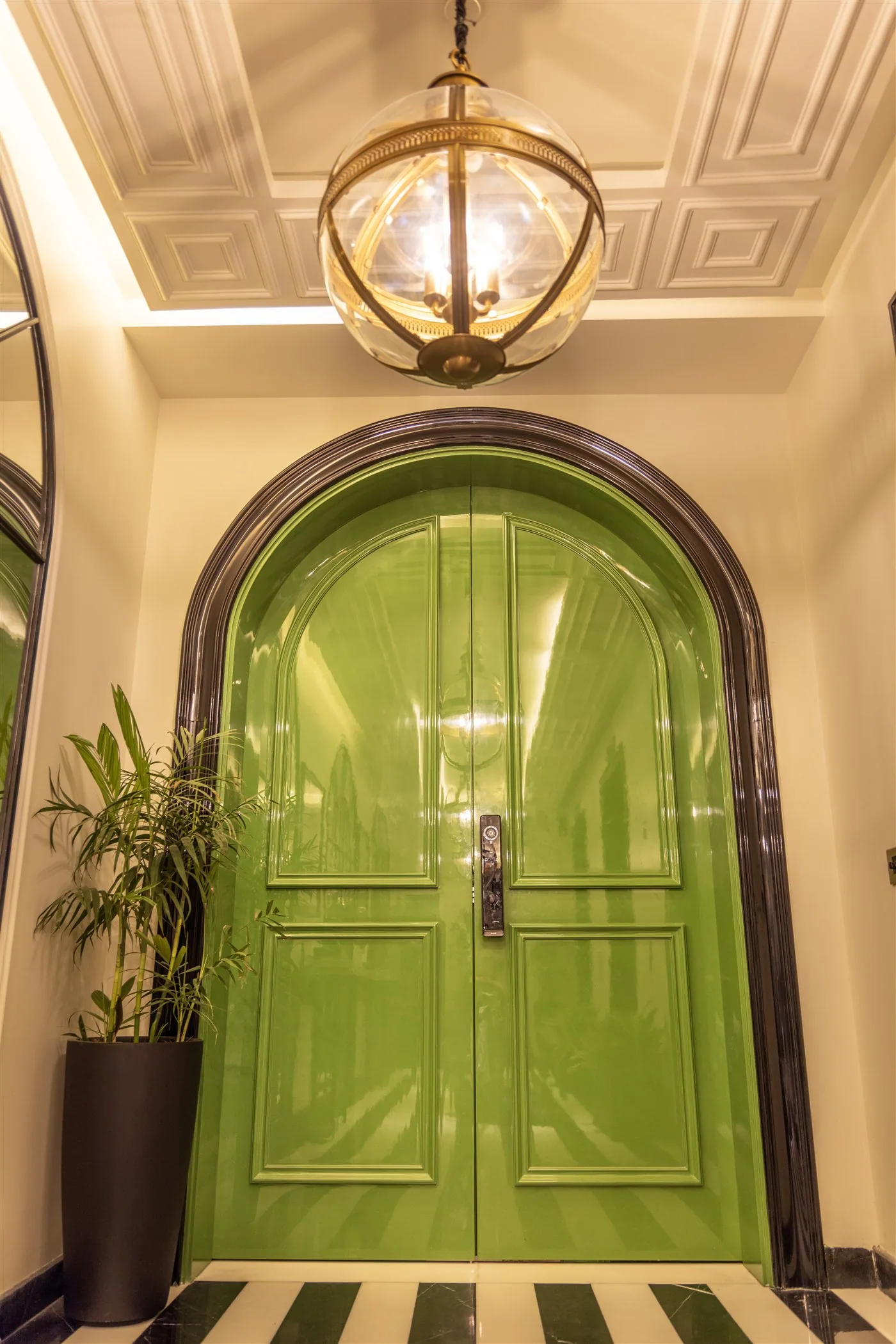 Arched lacquered entrance door under a coffered ceiling — 601, Camellias